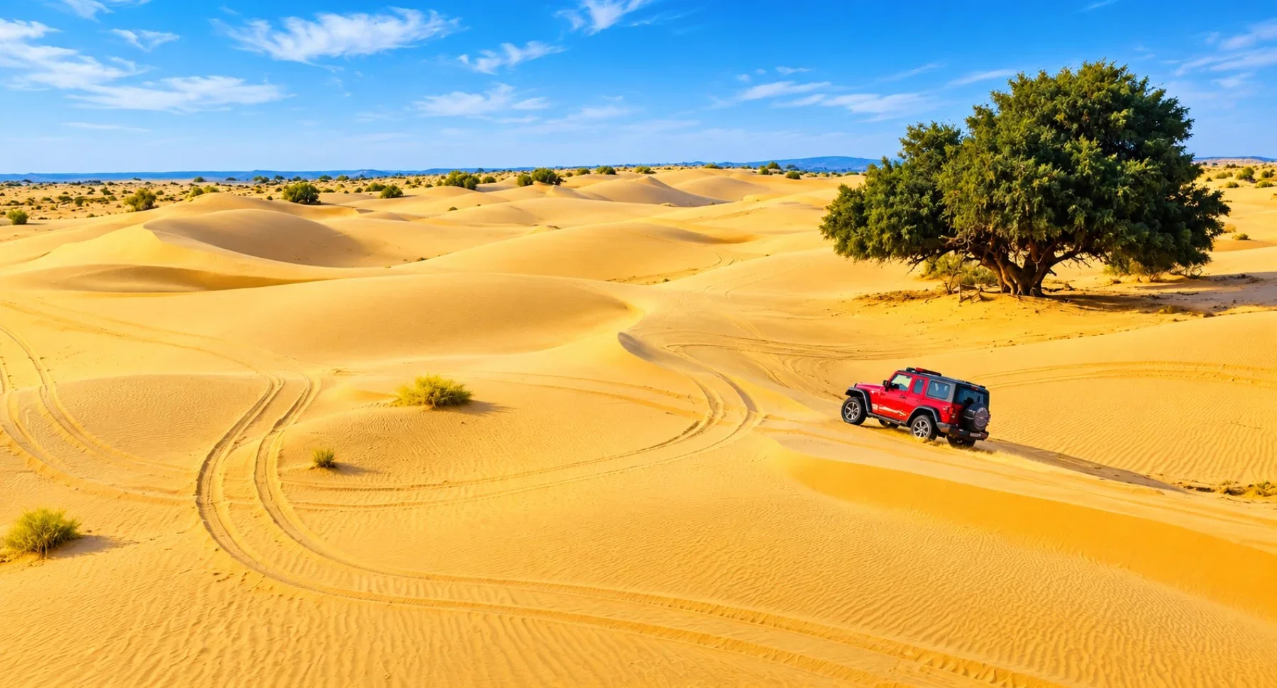 Red jeep racing across Sam Sand Dunes at blazing sunset
